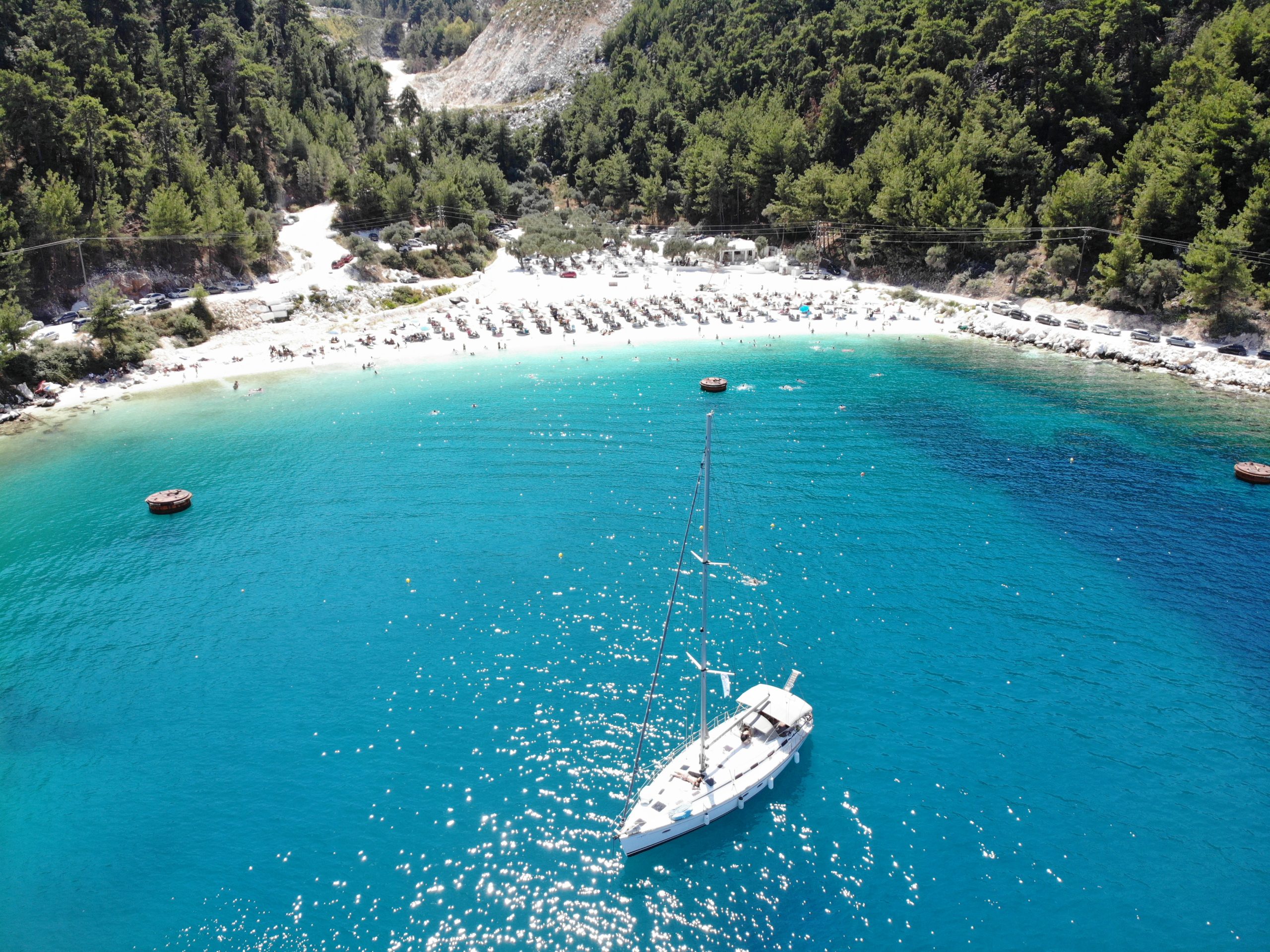 drone photo of porto vathy beach with a sail boat in view